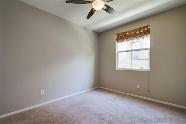 carpeted spare room featuring ceiling fan