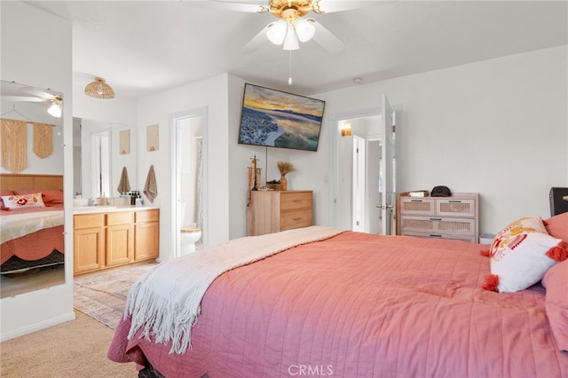 bedroom with connected bathroom, ceiling fan, sink, and light colored carpet