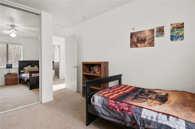 bedroom with a closet, light colored carpet, and ceiling fan