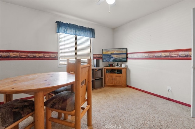 carpeted dining room with ceiling fan