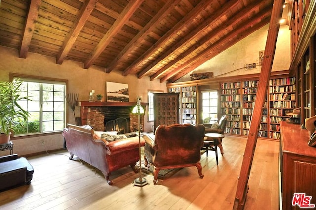 living room with beam ceiling, light hardwood / wood-style flooring, high vaulted ceiling, a fireplace, and wood ceiling