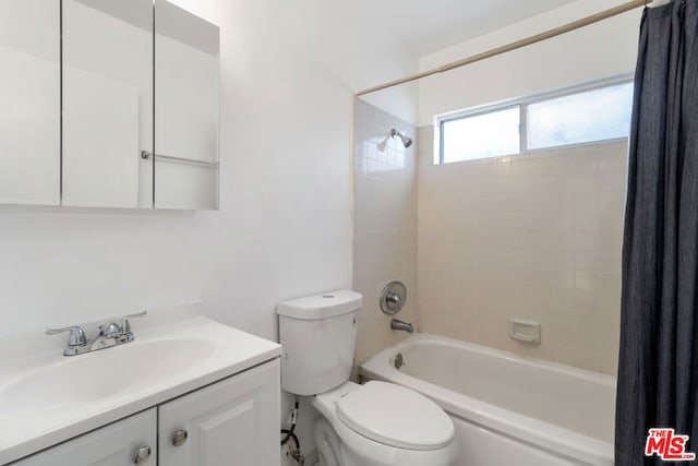 full bathroom with toilet, vanity, and shower / tub combo with curtain