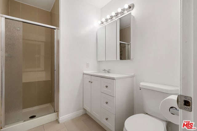 bathroom featuring toilet, vanity, tile patterned floors, and walk in shower