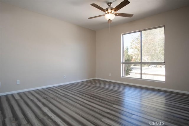 empty room featuring dark hardwood / wood-style flooring, a wealth of natural light, and ceiling fan