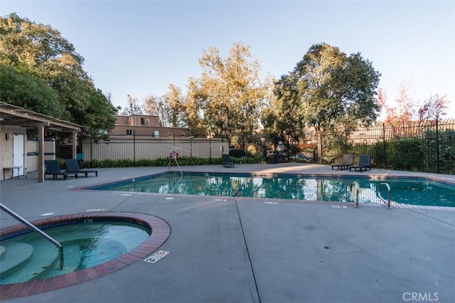 view of swimming pool with a patio area and a hot tub