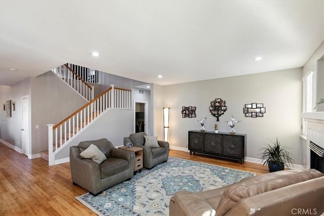 living room featuring a fireplace and light wood-type flooring