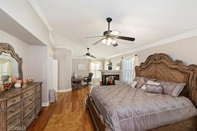 bedroom with ceiling fan, ornamental molding, and light wood-type flooring