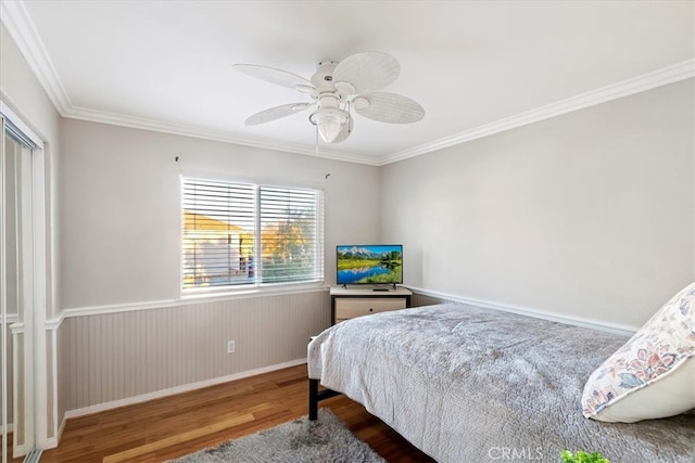 bedroom with ornamental molding, ceiling fan, and dark wood-type flooring