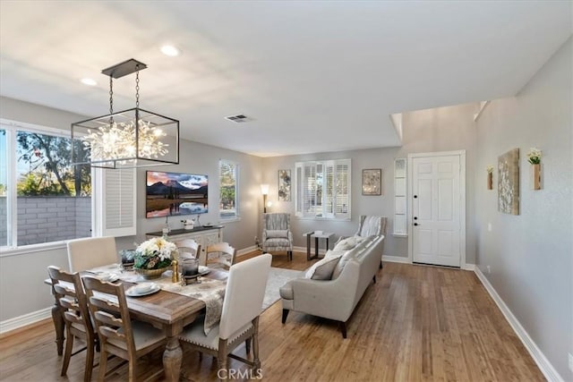 dining space featuring plenty of natural light, light hardwood / wood-style floors, and a notable chandelier