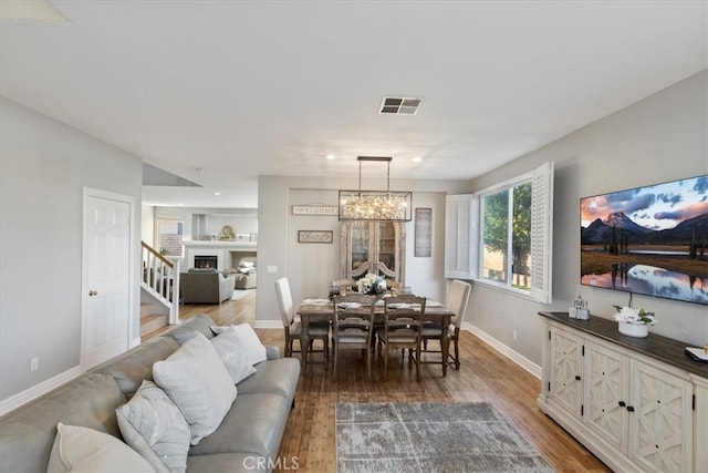 dining space with hardwood / wood-style flooring and an inviting chandelier