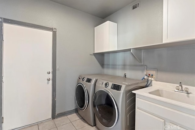 washroom featuring sink, light tile patterned floors, cabinets, and independent washer and dryer