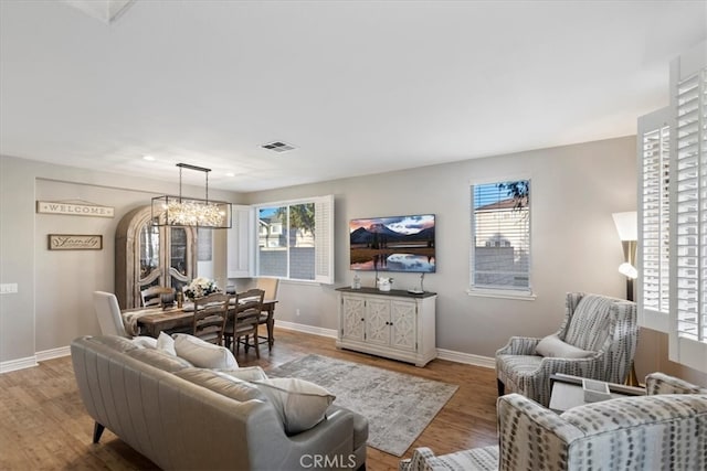 living room with hardwood / wood-style flooring, a notable chandelier, and a healthy amount of sunlight