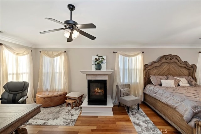 bedroom featuring ceiling fan, light wood-type flooring, and ornamental molding