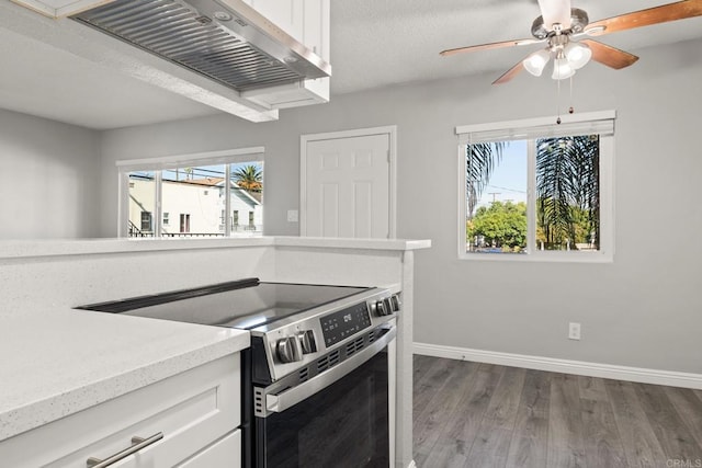 927 Daisy Ave, Long Beach, CA 90813 - kitchen featuring stainless steel range with electric stovetop, wood finished floors, baseboards, exhaust hood, and white cabinets