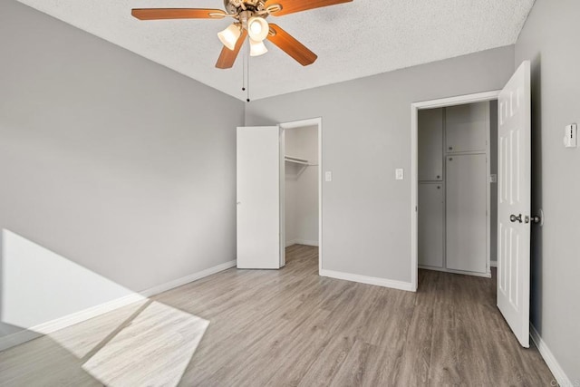 unfurnished bedroom featuring ceiling fan, light hardwood / wood-style flooring, and a textured ceiling