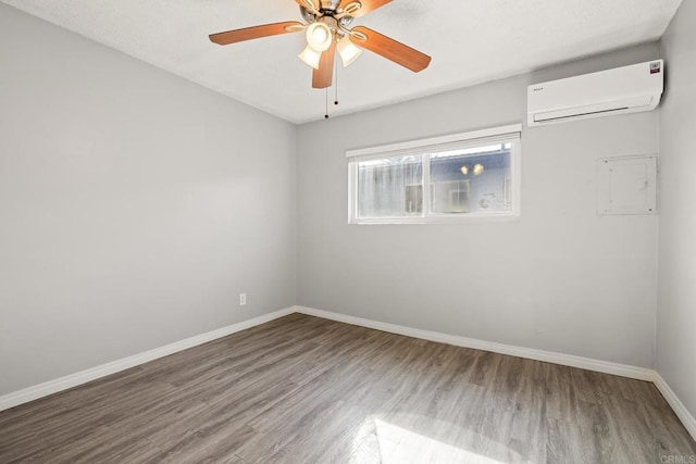 empty room featuring a wall unit AC, ceiling fan, and hardwood / wood-style flooring