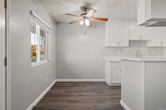 927 Daisy Ave, Long Beach, CA 90813 - kitchen with wall chimney exhaust hood, a ceiling fan, dark wood-type flooring, white cabinets, and light countertops