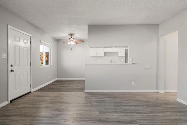 interior space featuring ceiling fan, dark hardwood / wood-style flooring, and a textured ceiling