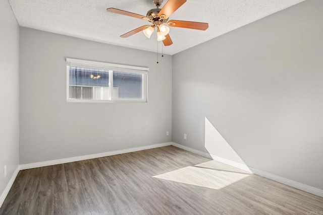 spare room with ceiling fan, a textured ceiling, and light wood-type flooring