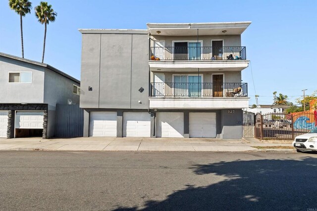 927 Daisy Ave, Long Beach, CA 90813 - rear view of house featuring a balcony, stucco siding, an attached garage, and a gate