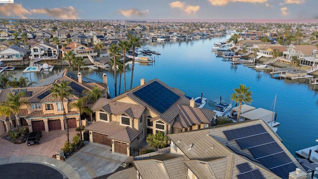 aerial view at dusk featuring a water view