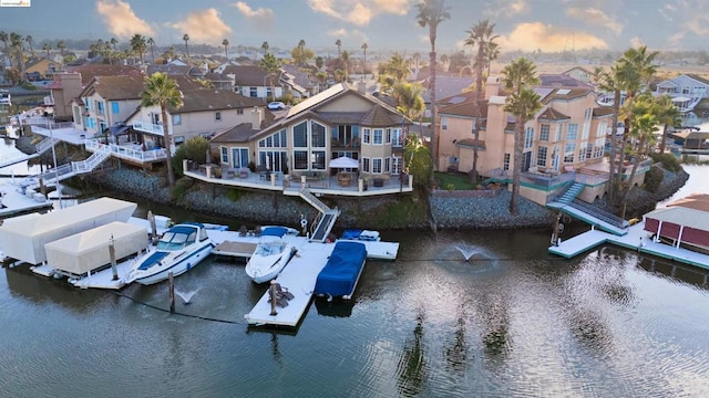 aerial view at dusk featuring a water view