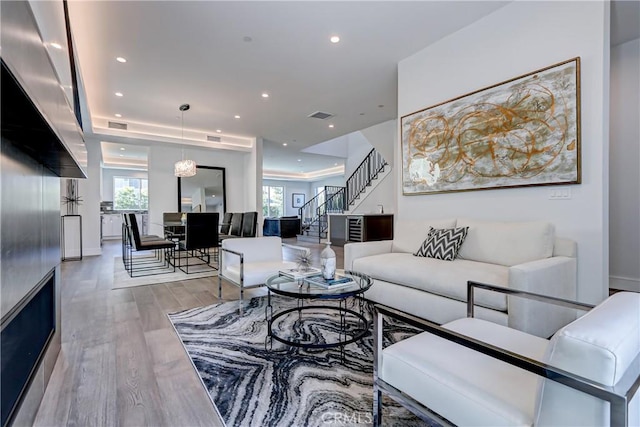 living room featuring light hardwood / wood-style floors and an inviting chandelier