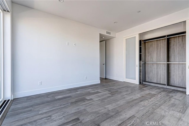 unfurnished bedroom with hardwood / wood-style floors and a closet