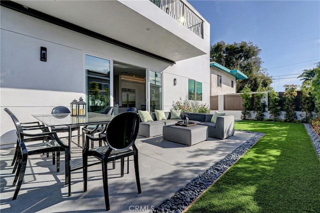 view of patio / terrace featuring a balcony and an outdoor living space with a fire pit