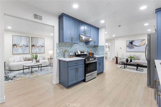 kitchen featuring tasteful backsplash, blue cabinetry, light wood-type flooring, and appliances with stainless steel finishes