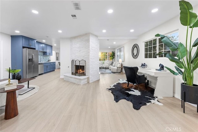 living room with a fireplace and light hardwood / wood-style floors