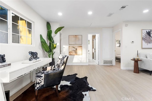 home office with light hardwood / wood-style floors