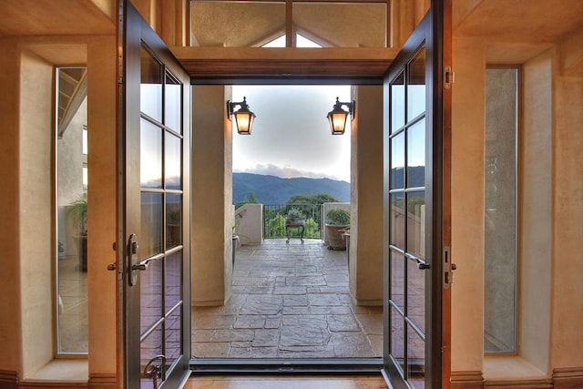 doorway with a mountain view, french doors, and lofted ceiling