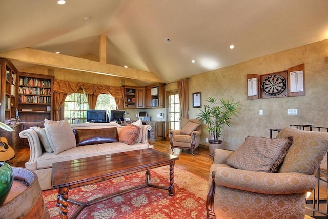 living room with light hardwood / wood-style floors and high vaulted ceiling