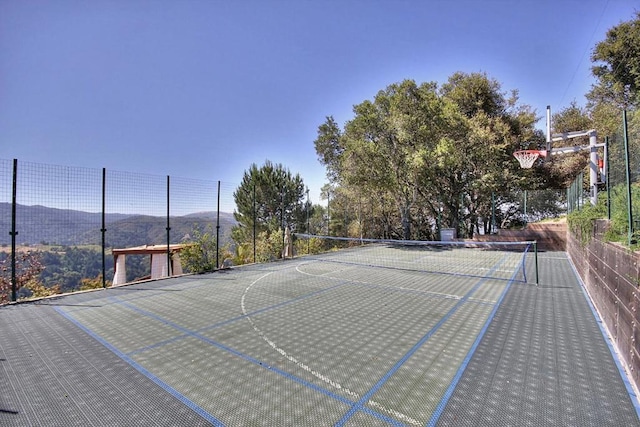 view of basketball court featuring tennis court and a mountain view