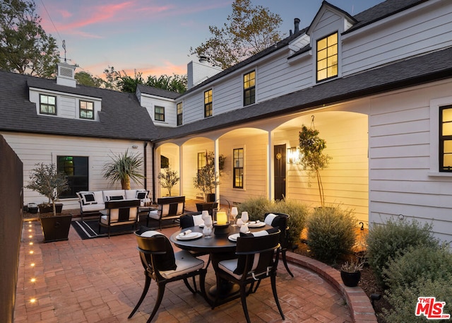 patio terrace at dusk featuring an outdoor hangout area