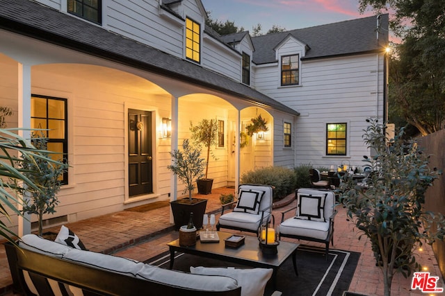 patio terrace at dusk featuring an outdoor hangout area