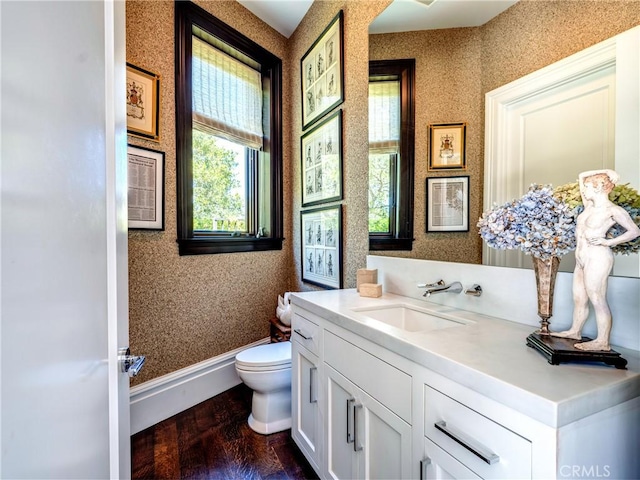 bathroom featuring wood-type flooring, vanity, and toilet