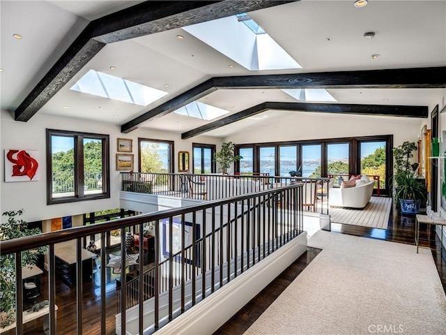 hall with hardwood / wood-style floors and vaulted ceiling with skylight