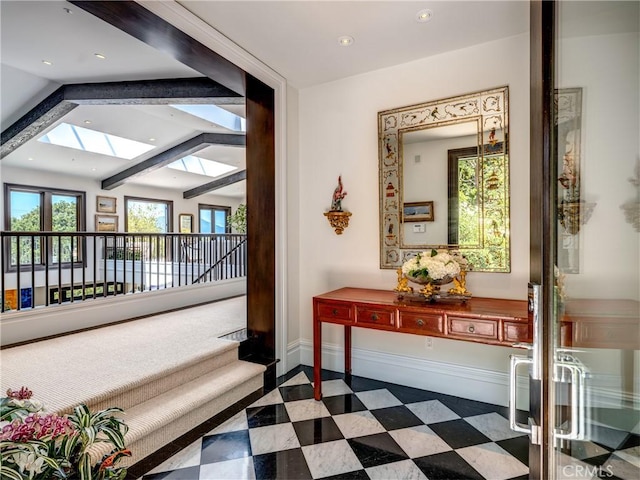 hall with vaulted ceiling with skylight and french doors