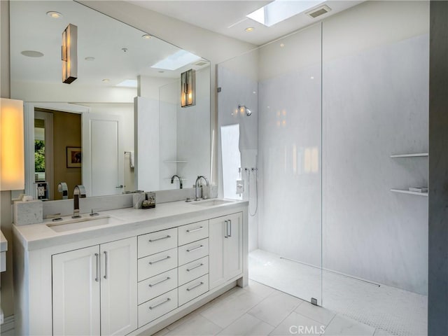 bathroom featuring tile patterned flooring, vanity, walk in shower, and a skylight