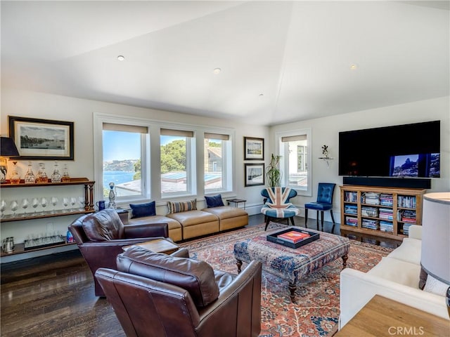 living room featuring hardwood / wood-style floors, vaulted ceiling, and bar