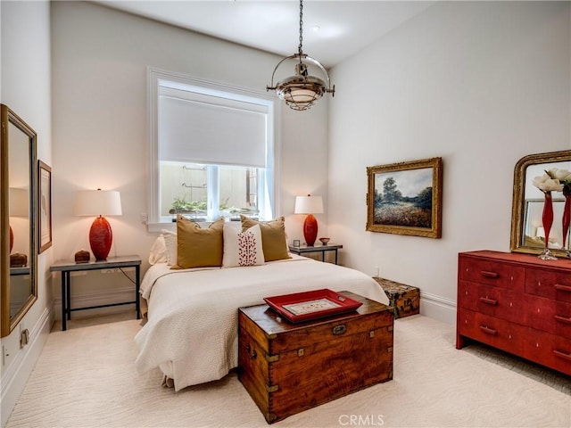 bedroom with light colored carpet and a chandelier