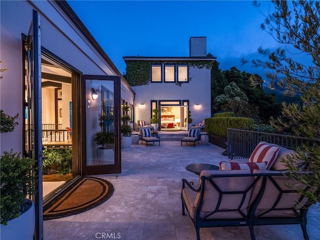 back of property with outdoor lounge area and a patio