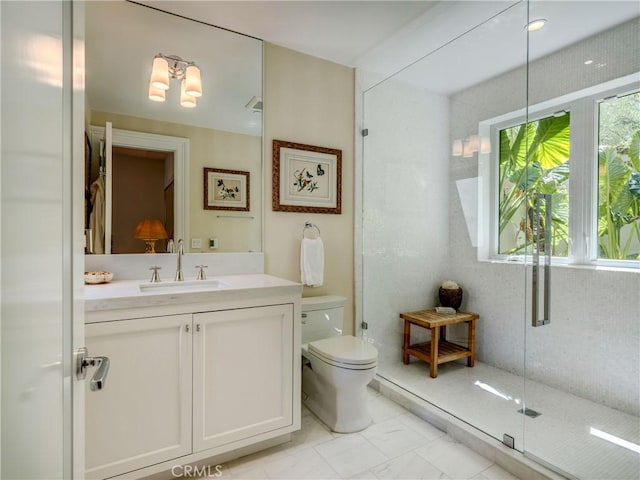 bathroom with a shower with door, vanity, and toilet