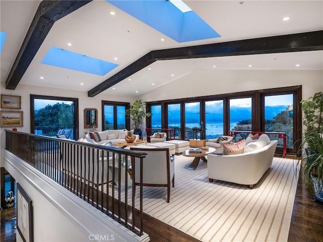 living room featuring wood-type flooring, a water view, and vaulted ceiling with skylight