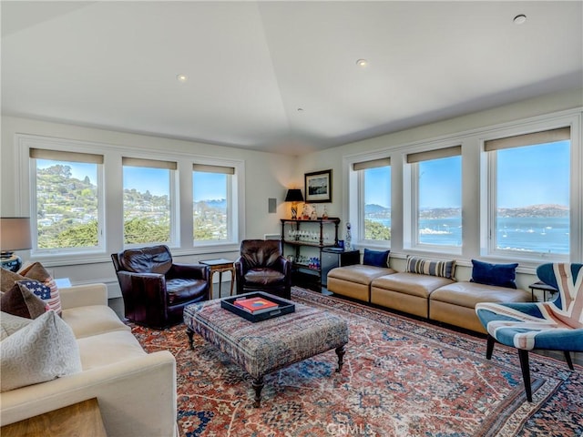 living room with a water view, a wealth of natural light, and lofted ceiling