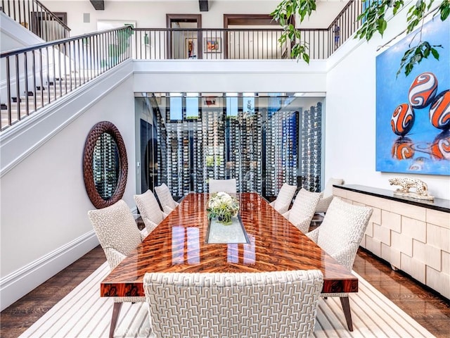 dining space with a high ceiling and hardwood / wood-style flooring