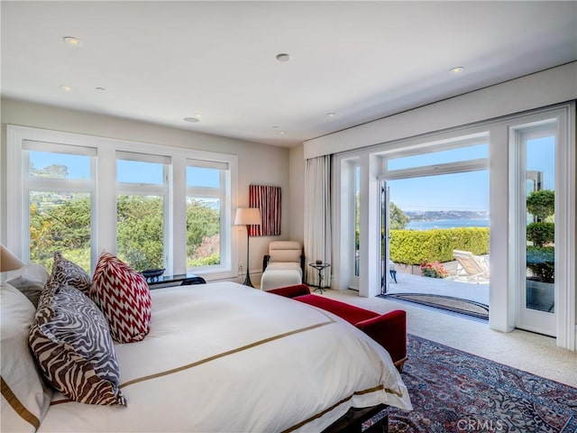 carpeted bedroom featuring access to exterior and a water view