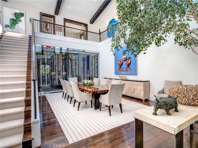 dining space featuring lofted ceiling with beams and dark hardwood / wood-style flooring